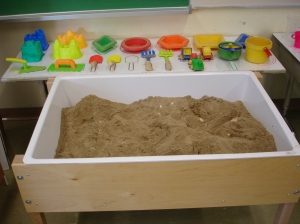 We chose to put out familiar sand tools and continue our extension of summer experiences with sand castle molds. All the materials are placed on a mat so children know where to put them when they are finished.